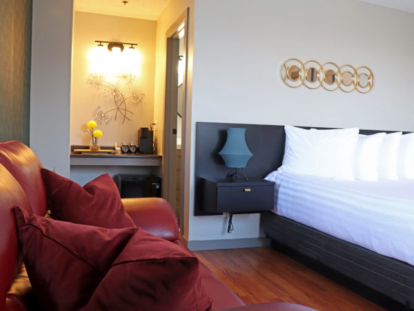 Nouveau room with a red couch, queen bed, ArtDeco accents